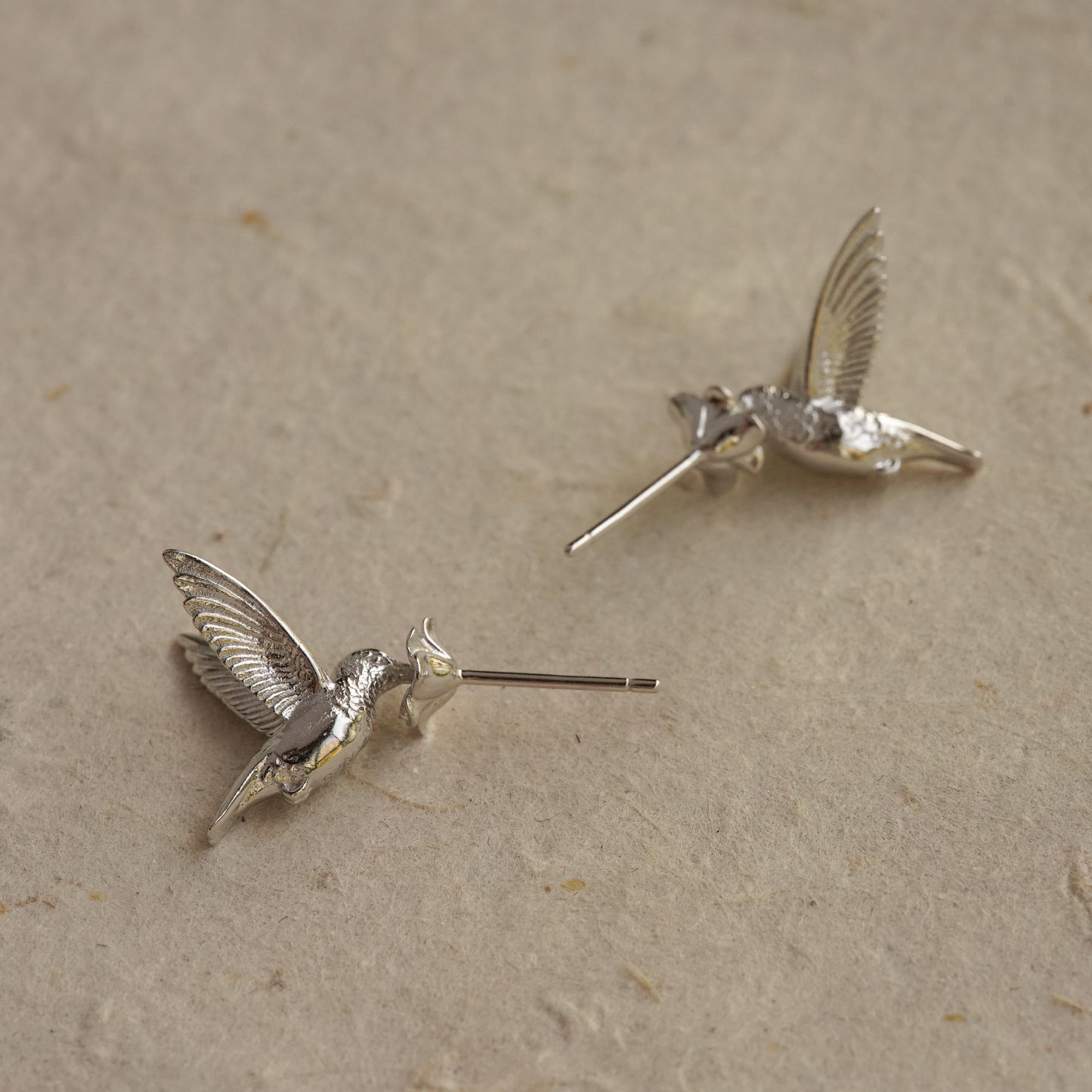 A pair of silver hummingbird earrings