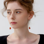 Red and green holiday gemstone earrings with gold bow detail for festive outfits