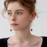 Red and green holiday gemstone earrings with gold bow detail for festive outfits