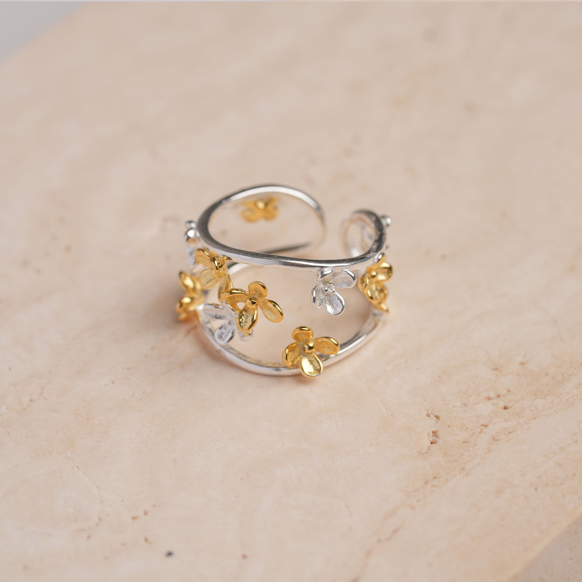 Adjustable osmanthus ring displayed on neutral background