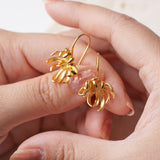 Dainty chrysanthemum dangle earrings displayed as a pair