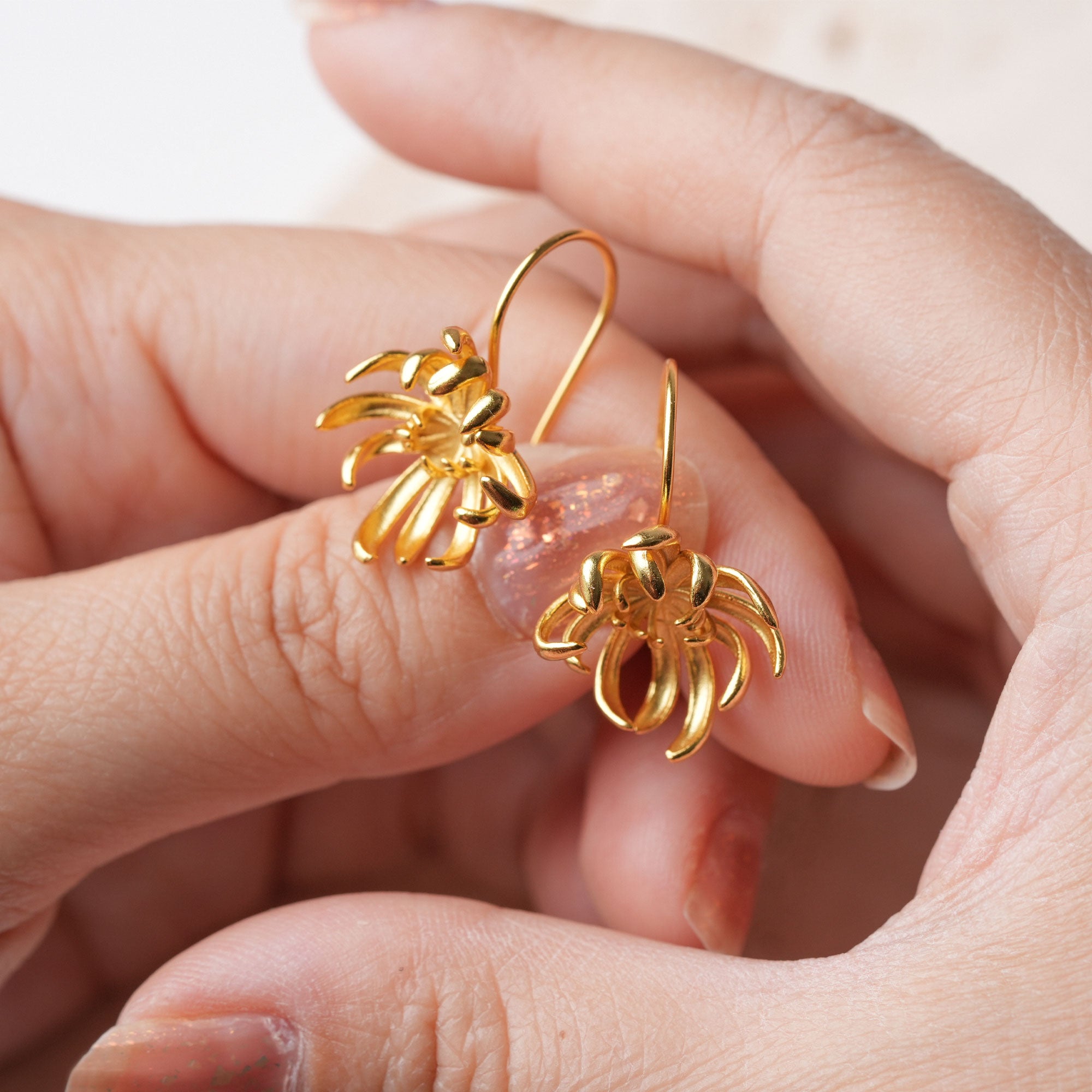 Dainty chrysanthemum dangle earrings displayed as a pair