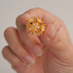 Gold plated cornflower ring displayed on neutral background