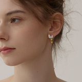 Gold and silver carrot earrings with silver leaf details on model