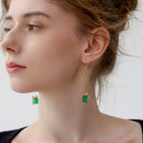 Green jade Christmas earrings with gold bow displayed on model