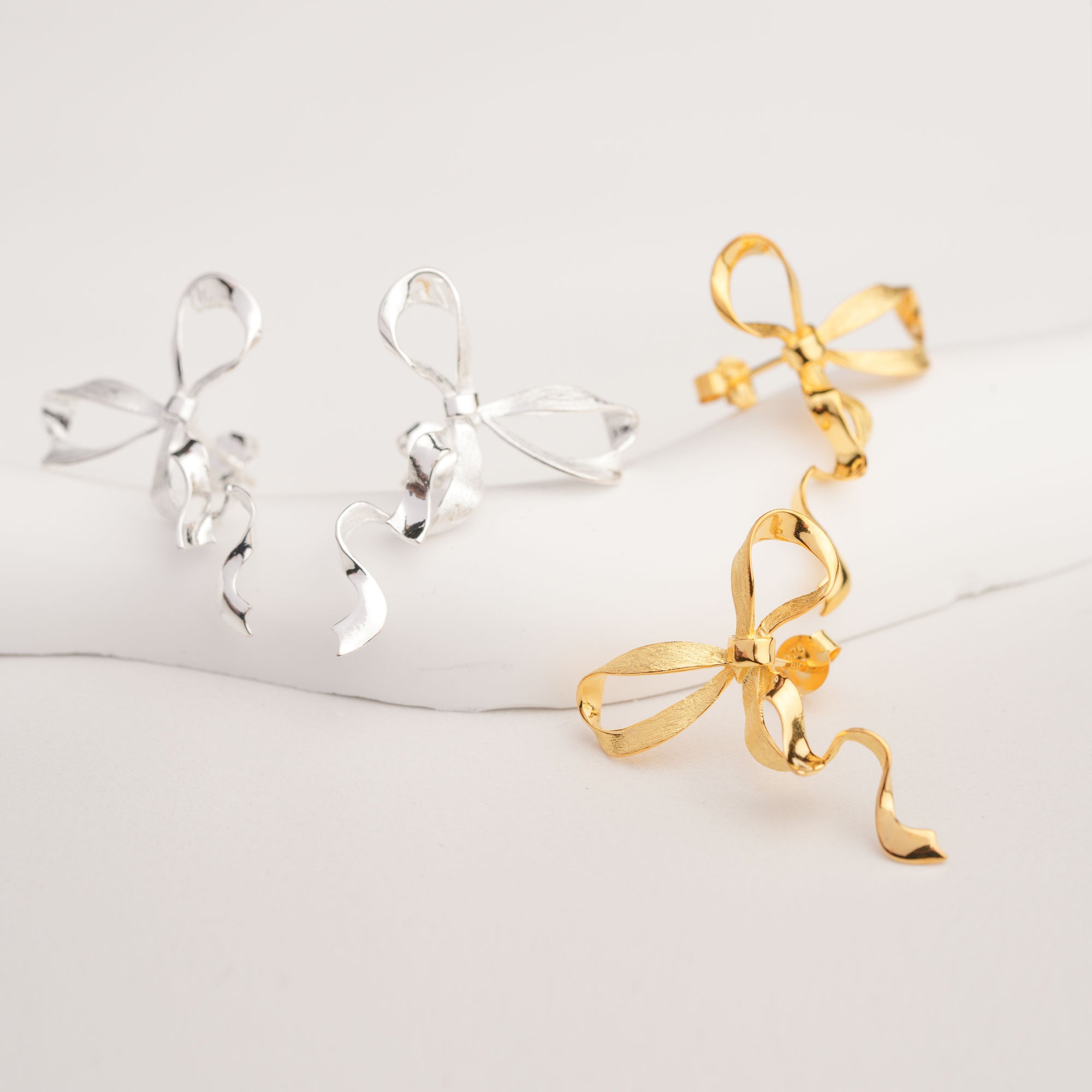 Knot earrings displayed on neutral background