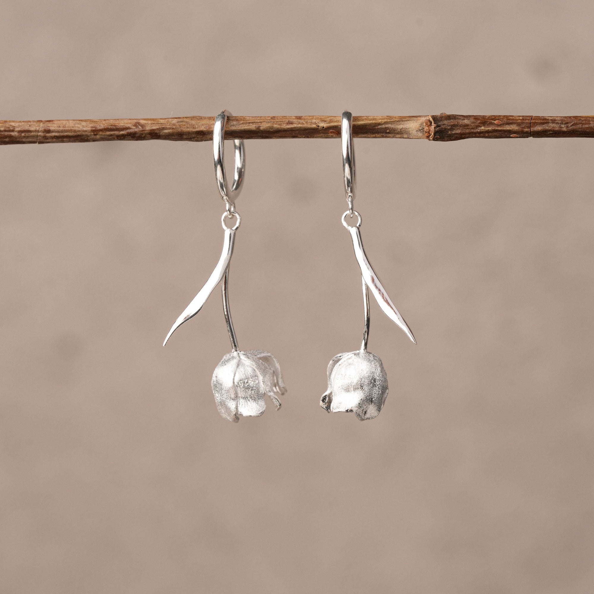 Silver tulip flower huggie earrings