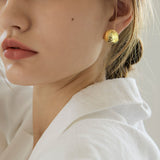 Woman wearing rose dome floral earrings