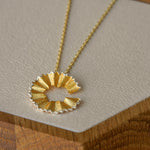 Art pencil necklace displayed on neutral background