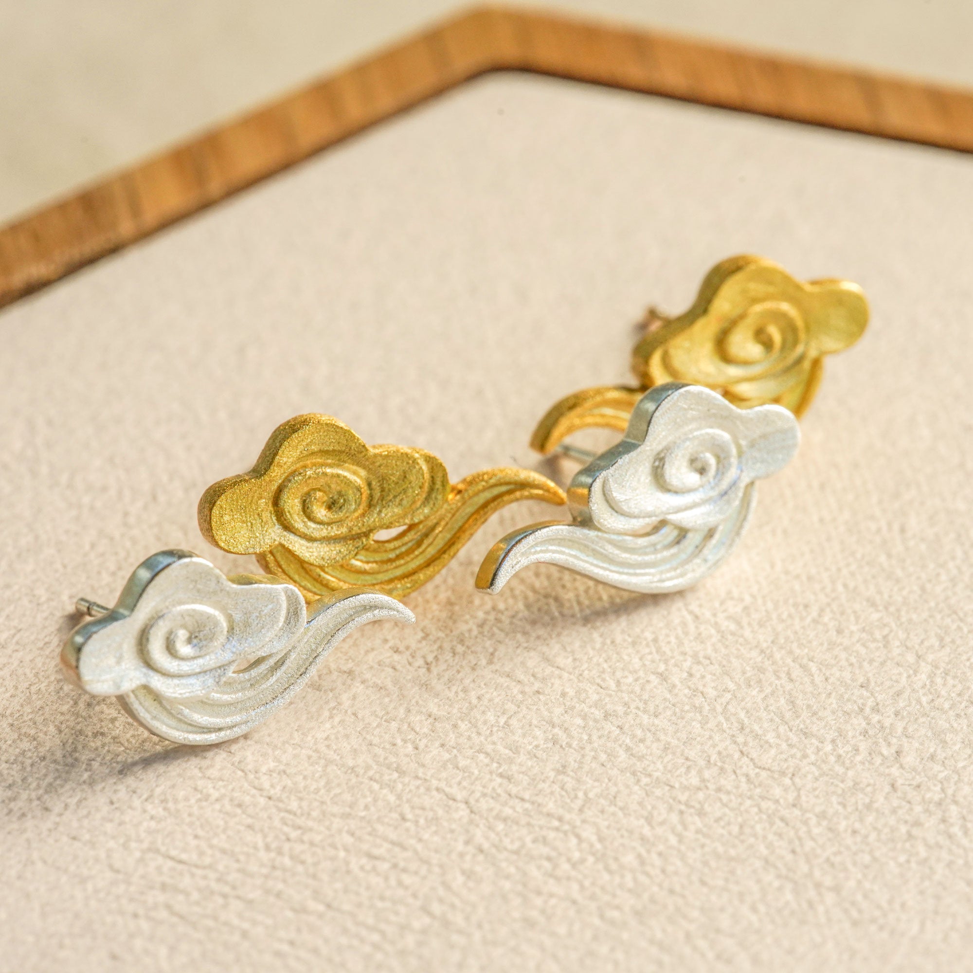 Close-up of cloud earrings showing curved shape