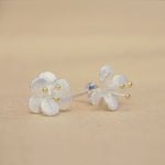Close-up of crab apple flower earrings showing petal details