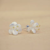Close-up of crab apple flower earrings showing petal details