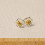 Close-up of daisy earrings showing petal details