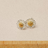 Close-up of daisy earrings showing petal details