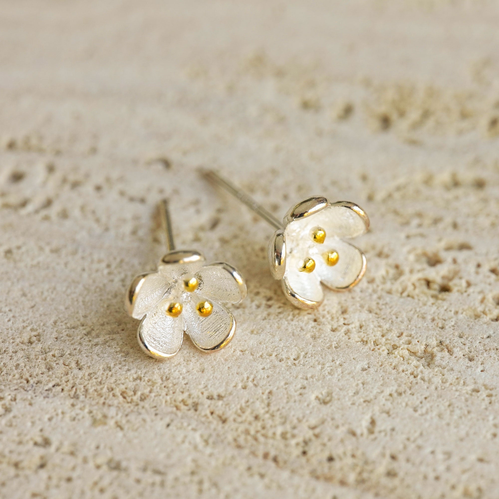 Close-up of flower stud earrings showing petal details