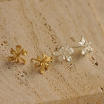 Close-up of iris earring studs showing flower details