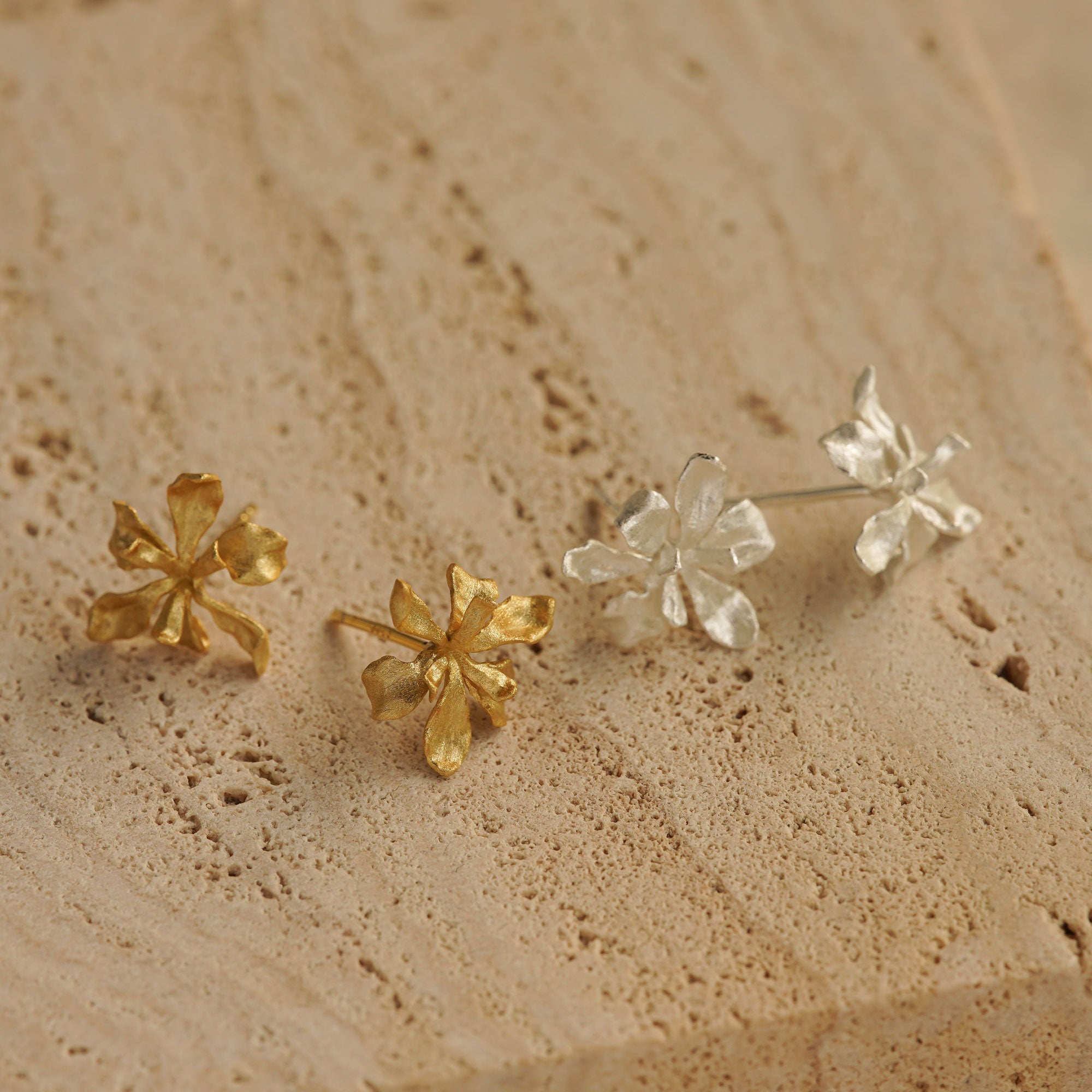 Close-up of iris earring studs showing flower details
