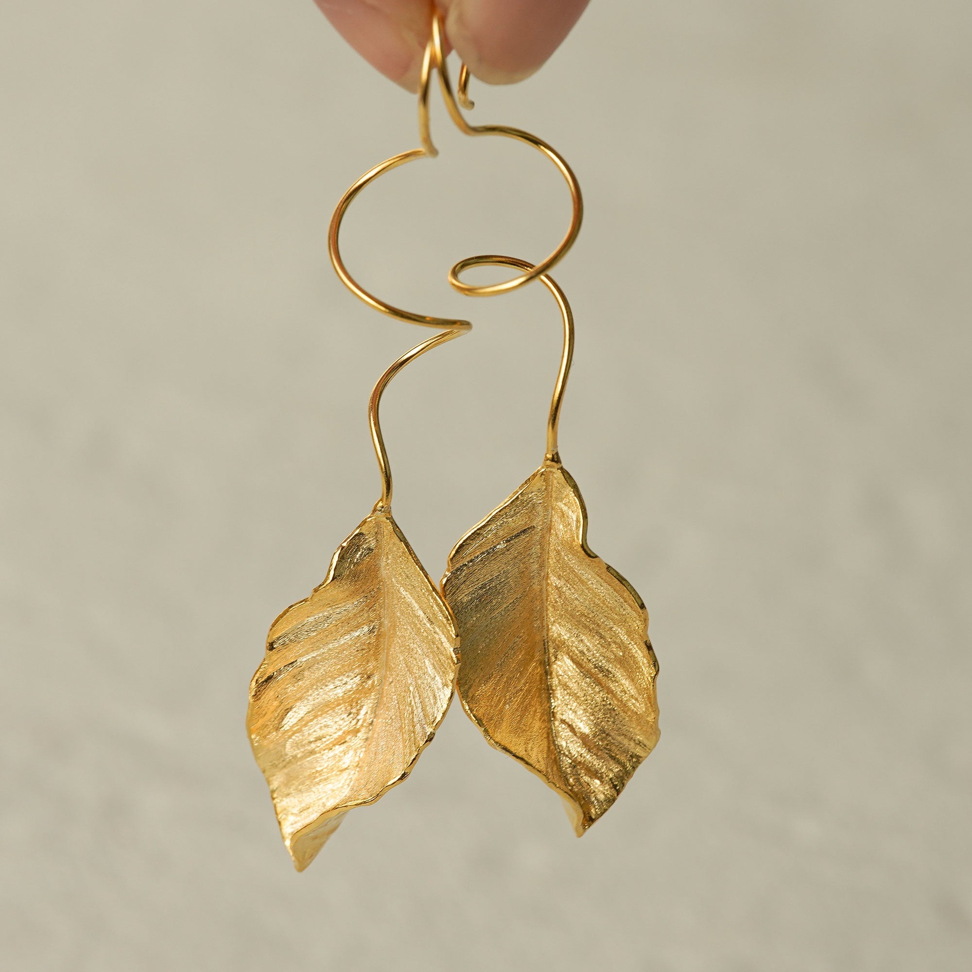 Close-up of leaf dangle earrings showing vein details