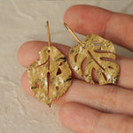 Close-up of monstera leaf earrings showing cutout details