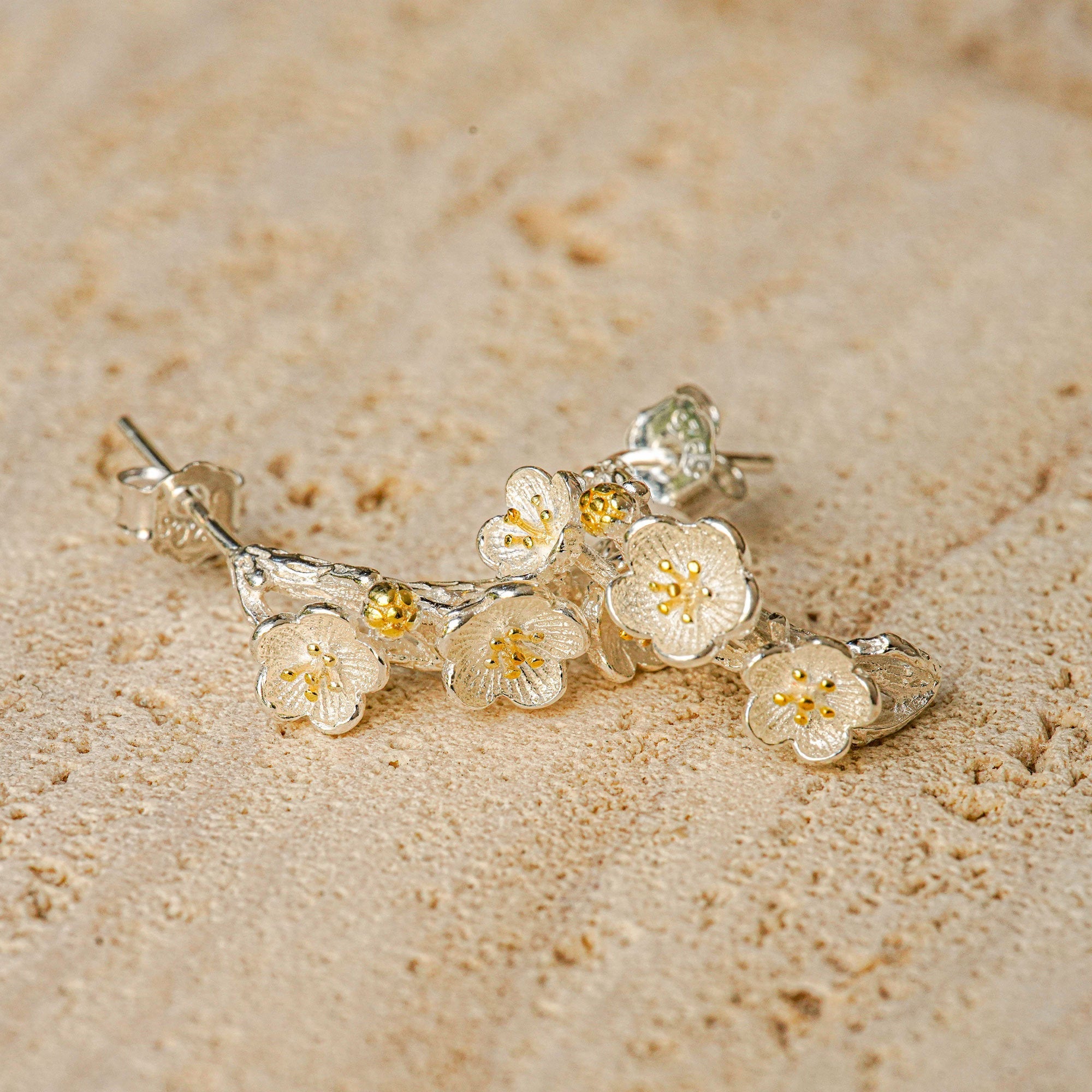 Close-up of plum blossom earrings showing petal details