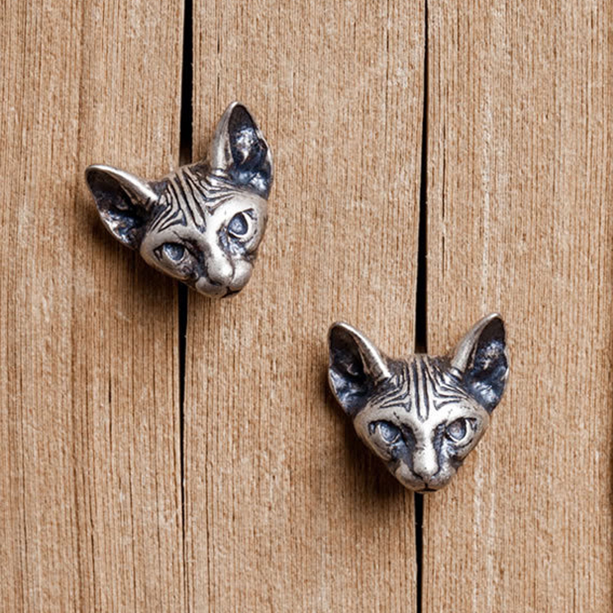 Close-up of sphinx cat earrings showing cat details