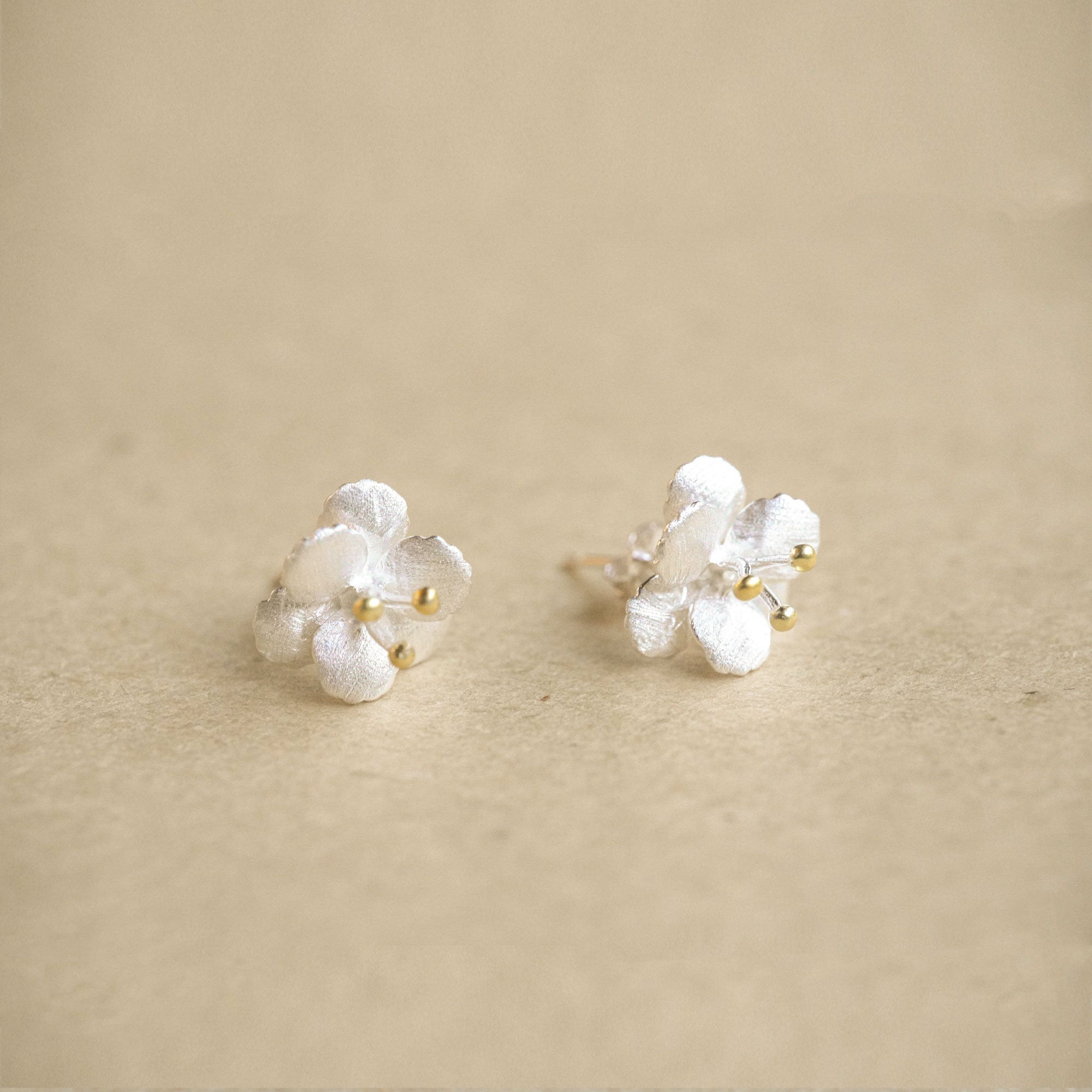 Crab apple flower earrings on a neutral product background