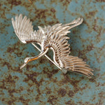 Close-up of crane bird brooch showing feather details