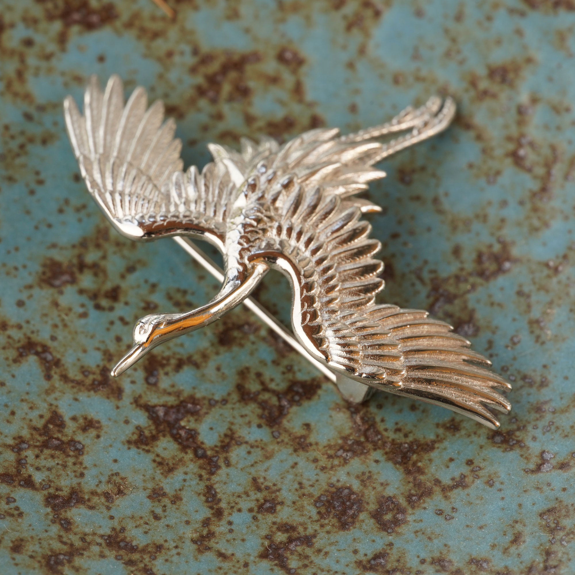 Close-up of crane bird brooch showing feather details