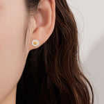 Daisy earrings on neutral product background