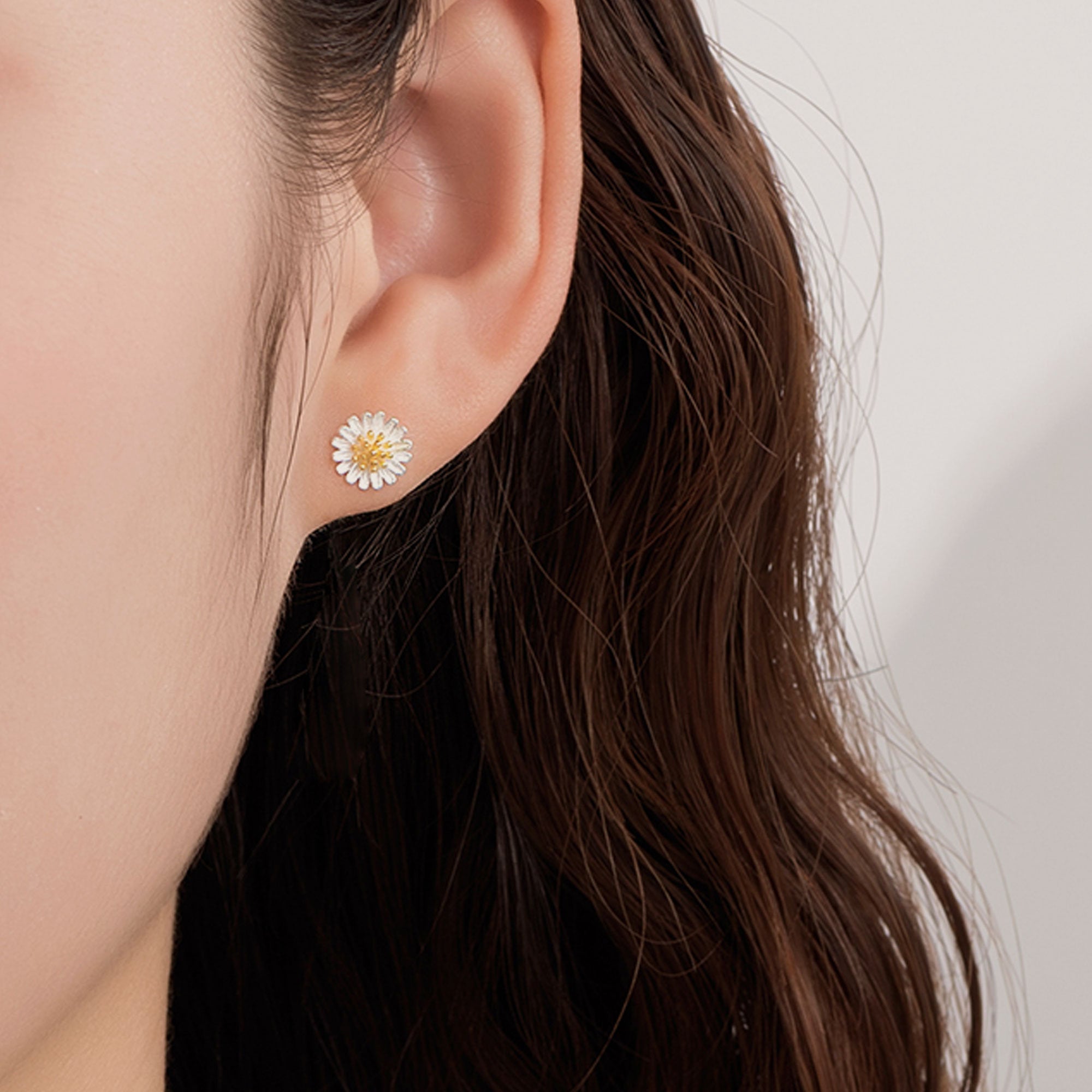 Daisy earrings on neutral product background