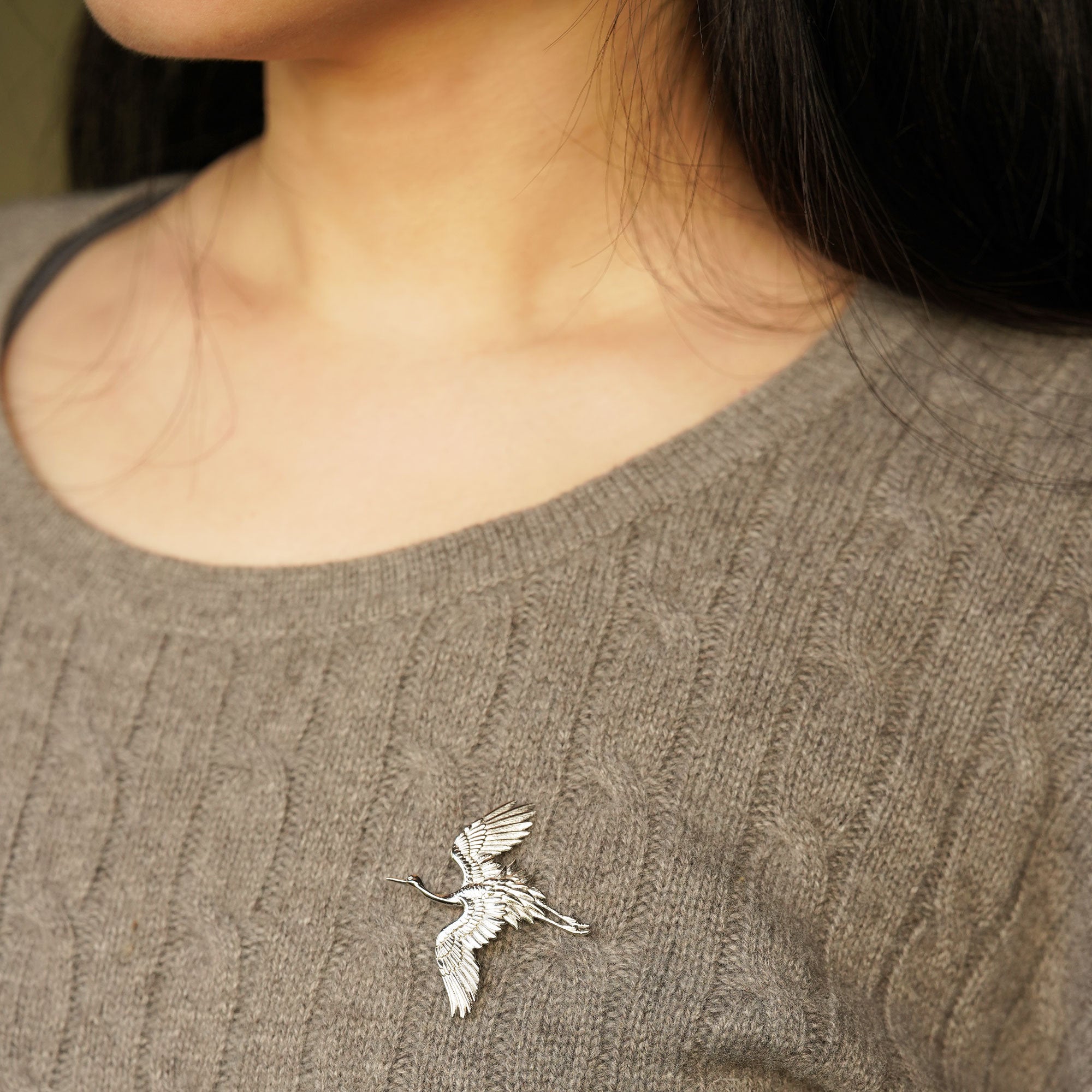 Detailed view of crane bird brooch