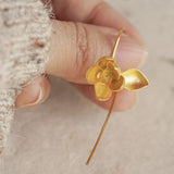 Gold magnolia flower earrings with botanical design