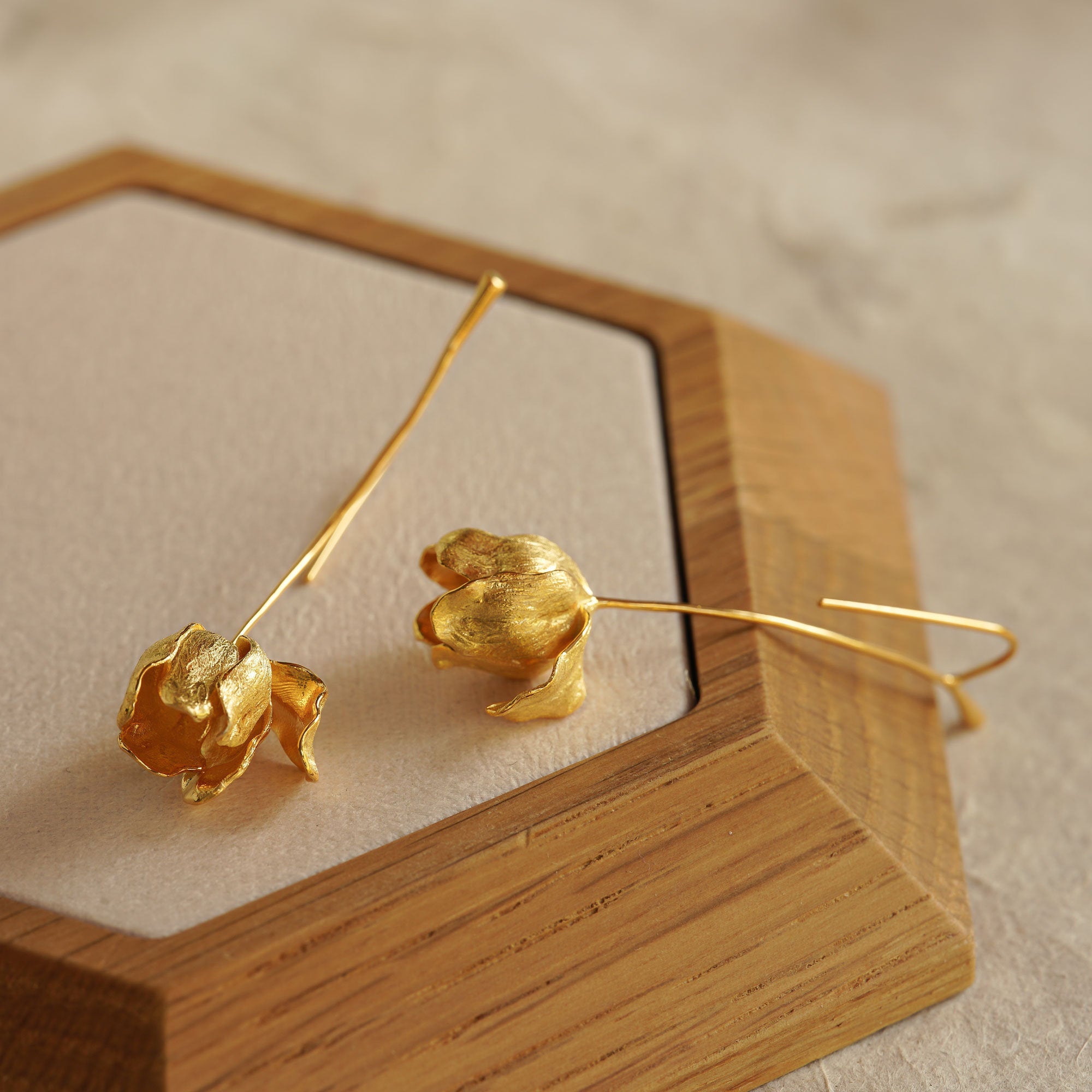 Side view of elegant gold tulip flower earrings, handcrafted with a natural petal design