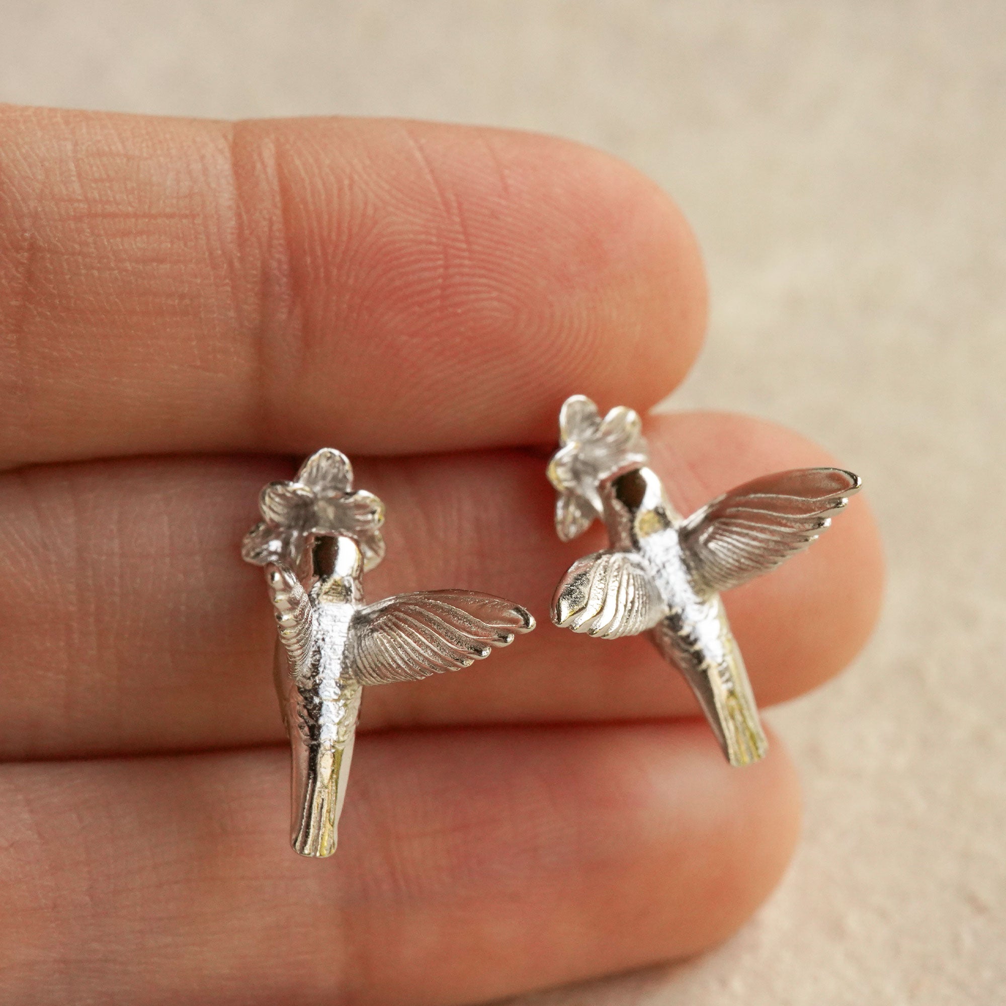 Hand holding hummingbird earrings for bird inspired jewelry