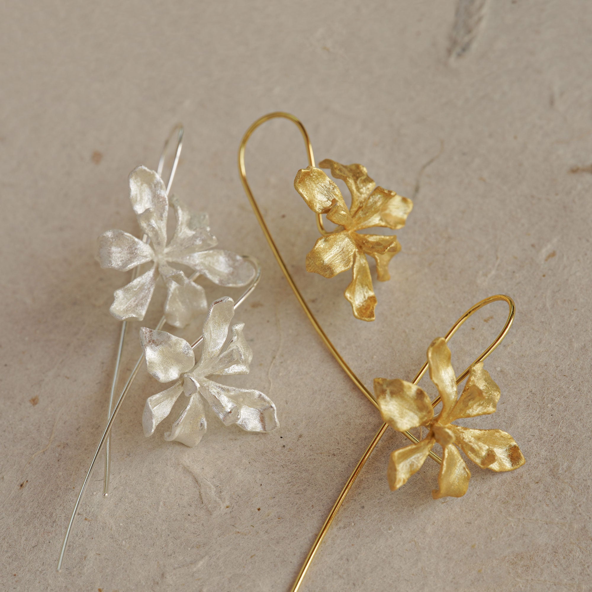 Iris drop earrings on a neutral product background