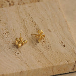 Iris stud earrings on a neutral product background