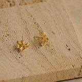 Iris stud earrings on a neutral product background