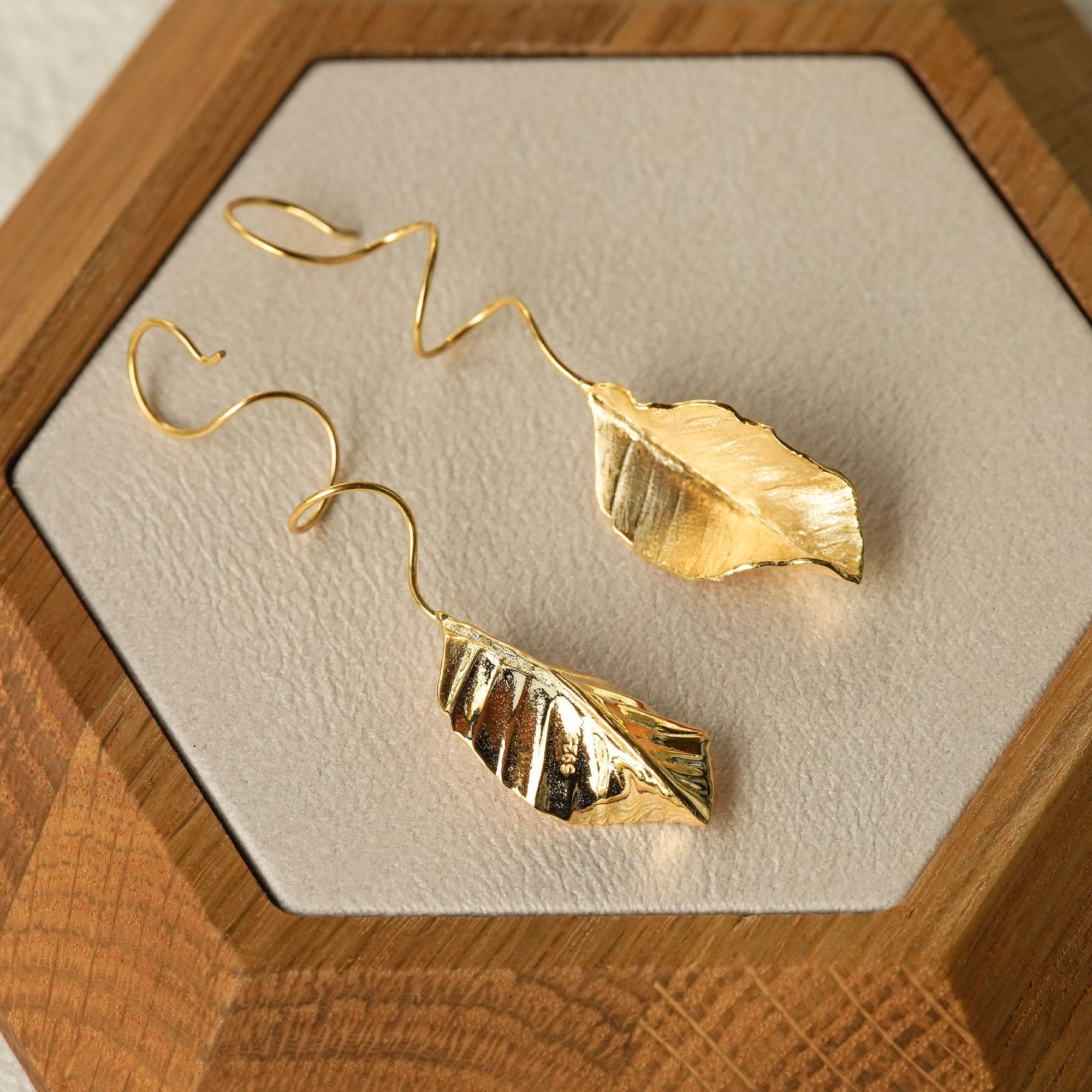 Leaf dangle earrings on neutral product background