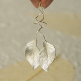 Leaf dangle earrings displayed as a pair