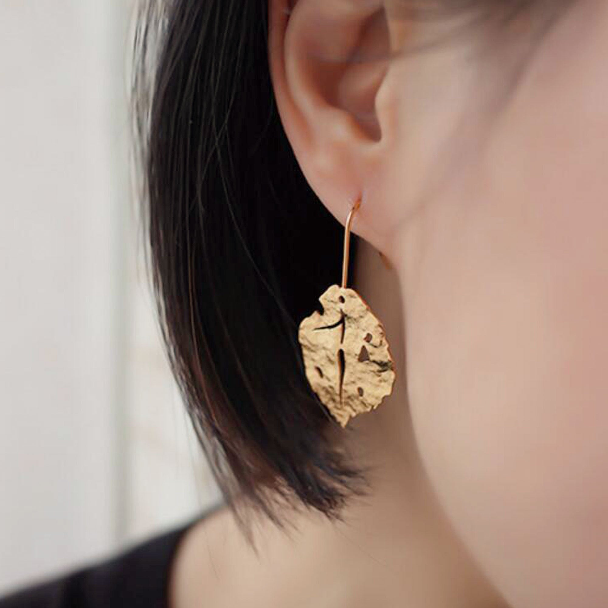 Leaf earrings on neutral product background