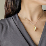 Leaf necklace displayed on neutral product background