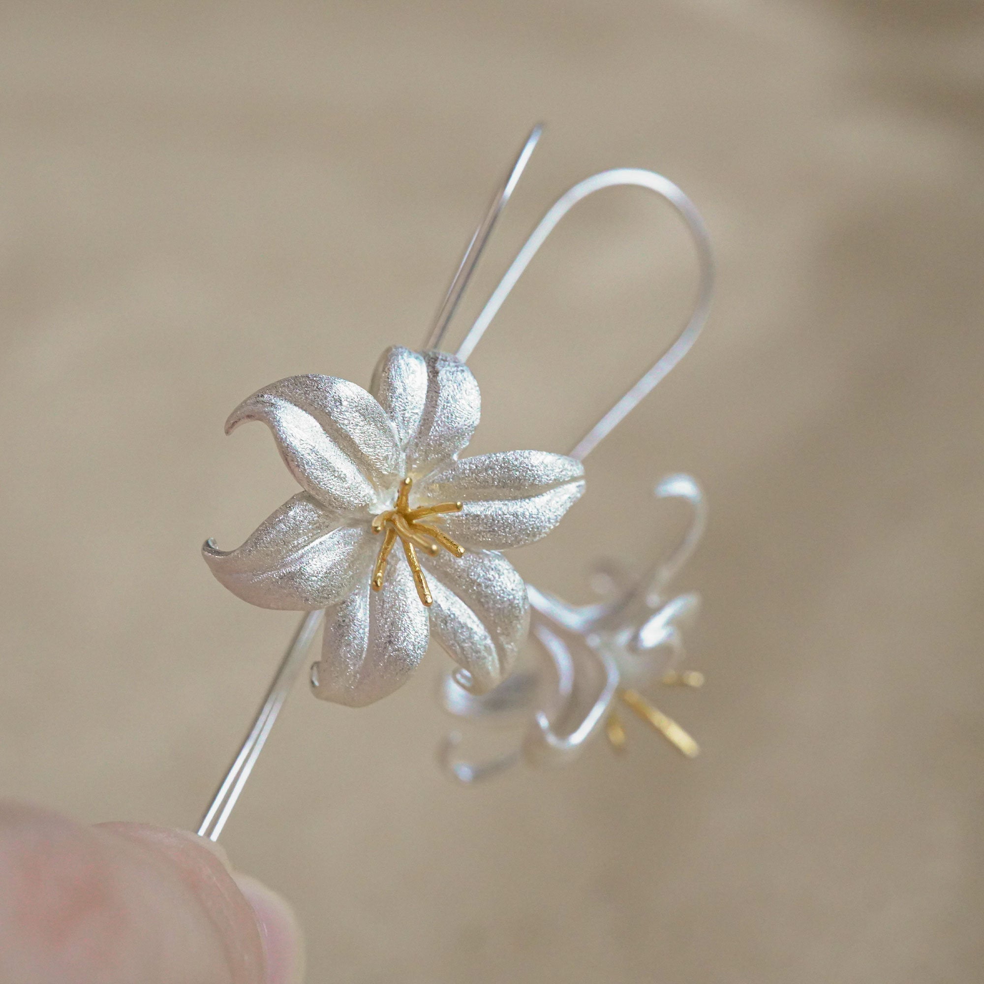 Lily drop earrings on a neutral product background