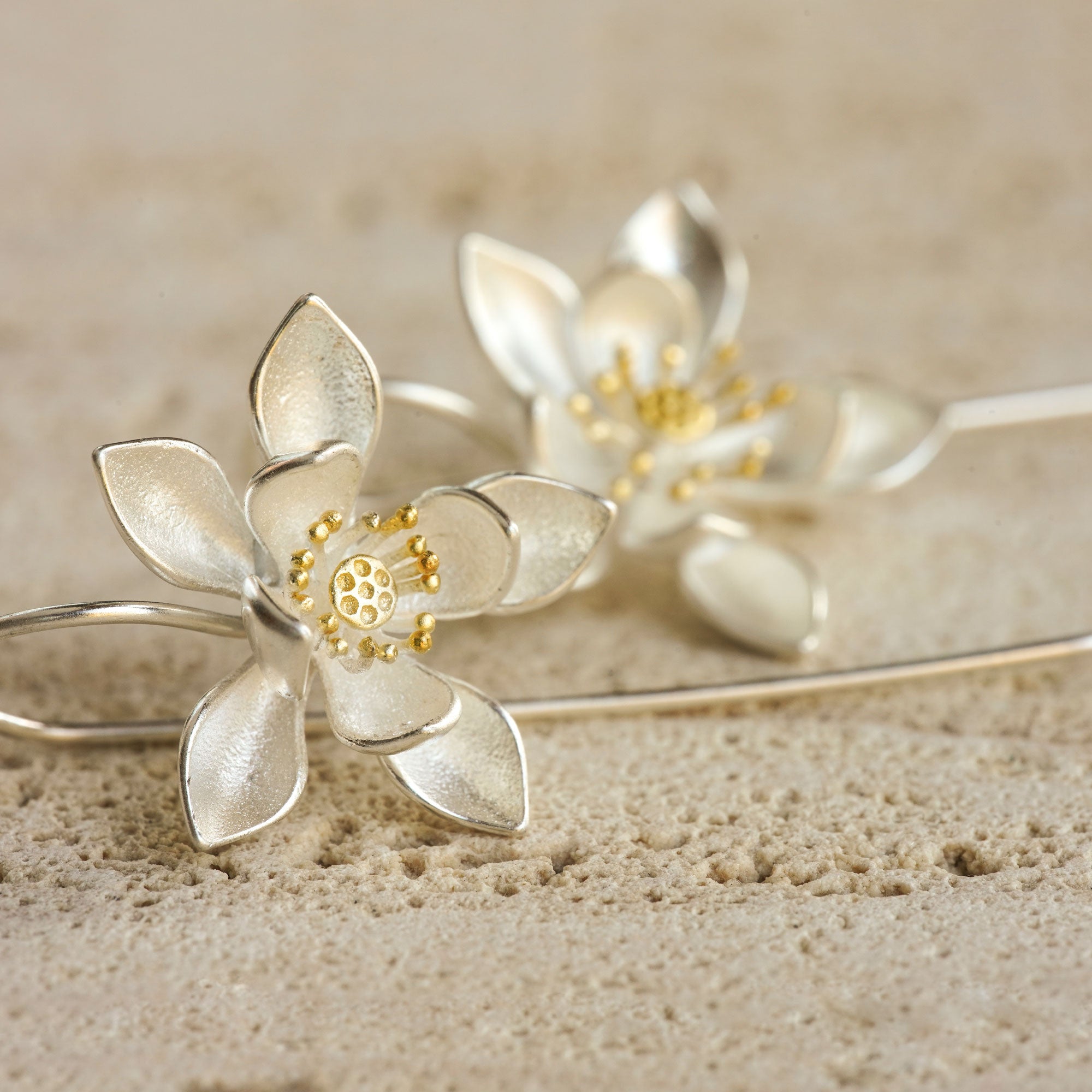 Lotus flower earrings displayed as a pair