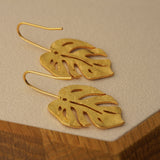Monstera earrings on neutral product background