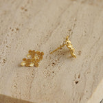 Osmanthus earrings on a neutral product background