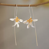 Osmanthus flower earrings hanging from a tree branch