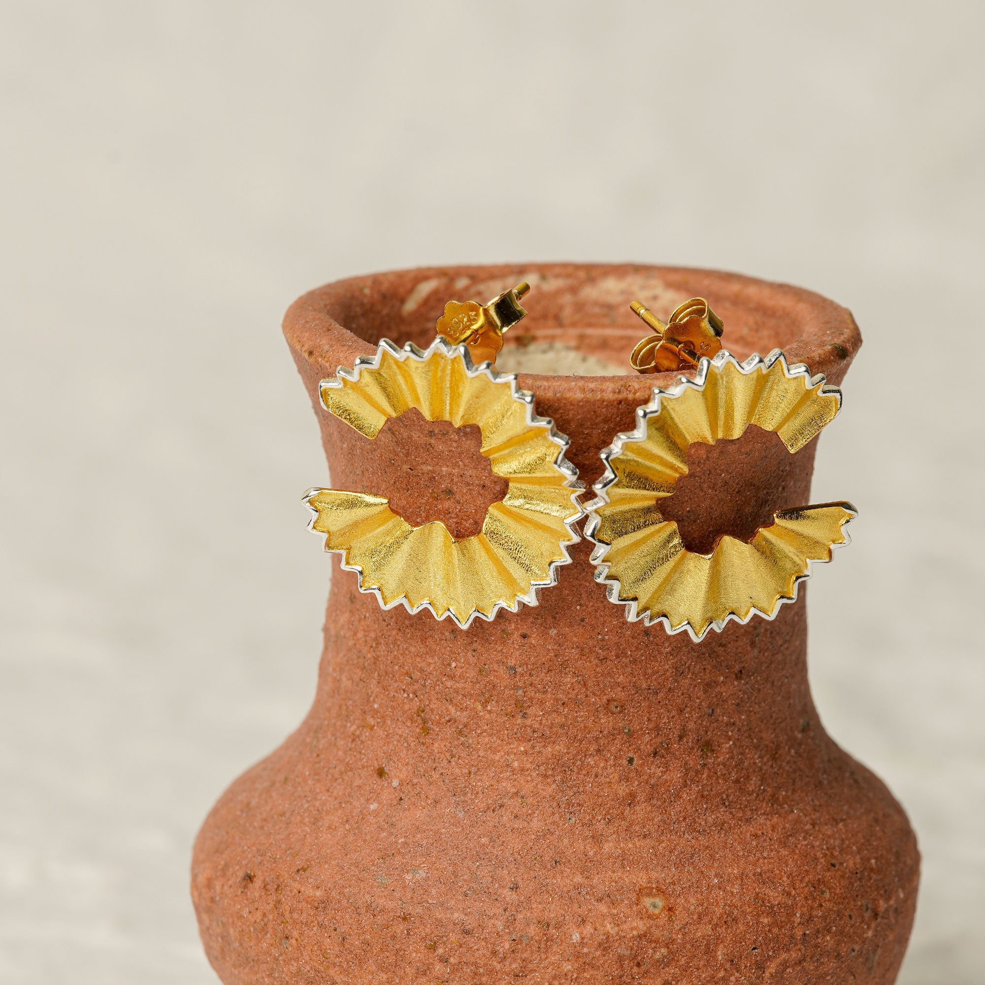 Pencil earrings on a neutral product background