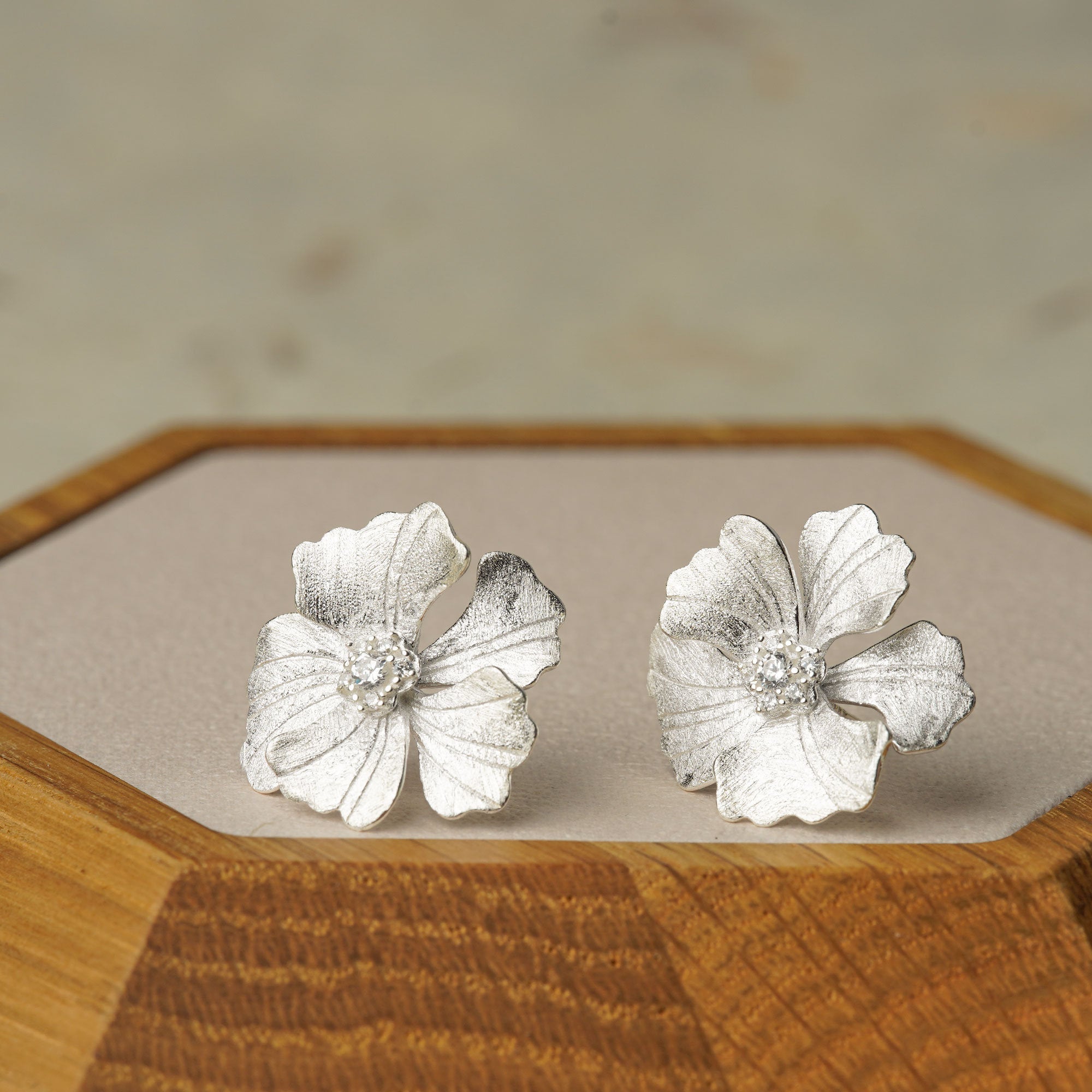 Peony earrings on a neutral product background