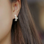 Plum blossom earrings on a neutral product background