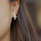 Plum blossom earrings on a neutral product background